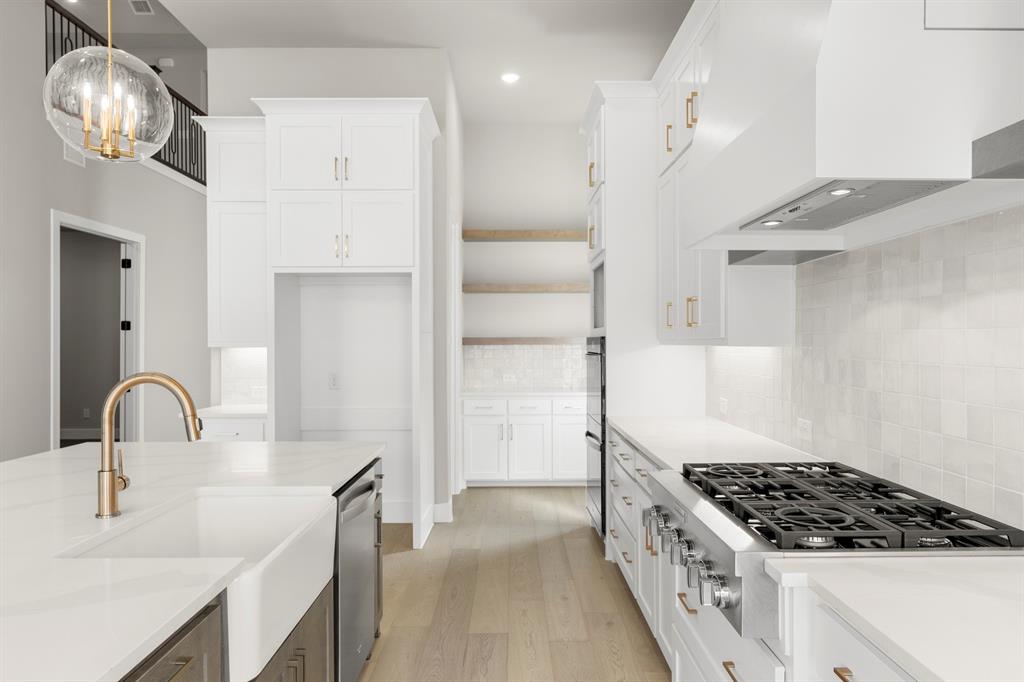4512 Meander Way Prosper, TX 75078 - Photo 13 of 39 a kitchen with stainless steel appliances granite countertop a sink a stove and a refrigerator
