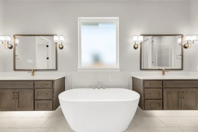 a spacious bathroom with a tub sink and mirror