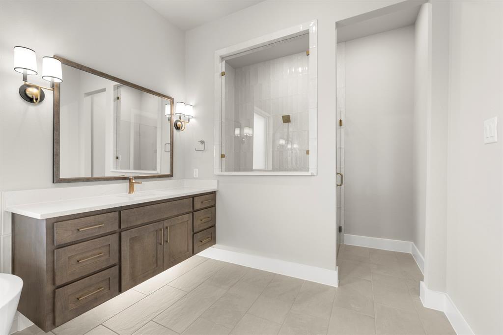4512 Meander Way Prosper, TX 75078 - Photo 17 of 39 a bathroom with a sink and a mirror