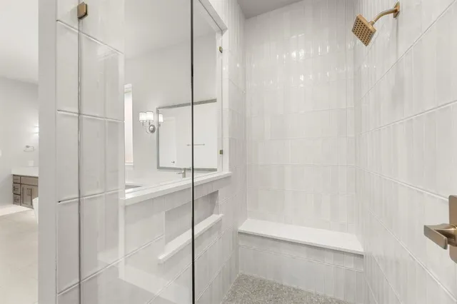 a bathroom with a shower and a glass door