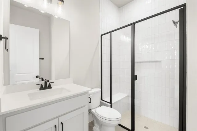 a bathroom with a sink a toilet and shower