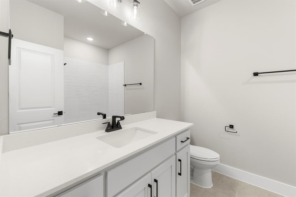 4512 Meander Way Prosper, TX 75078 - Photo 26 of 39 a bathroom with a sink a toilet and shower