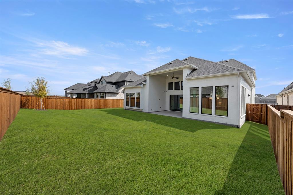 4512 Meander Way Prosper, TX 75078 - Photo 31 of 39 a front view of a house with a garden and yard