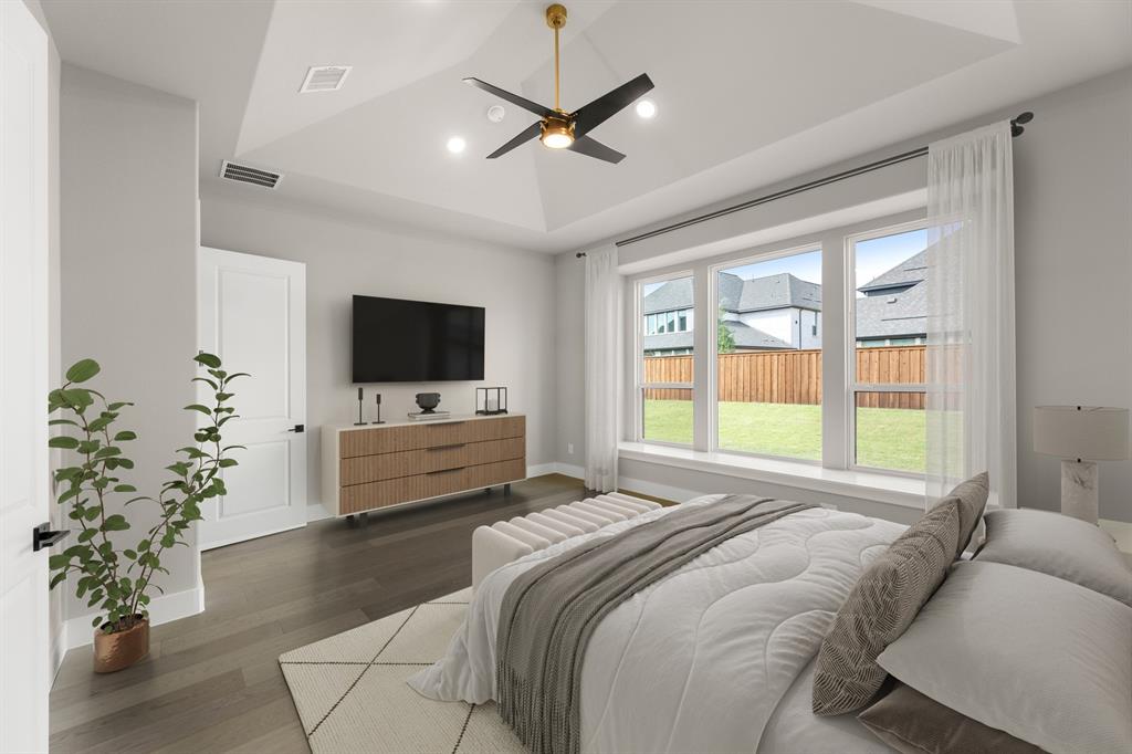 4512 Meander Way Prosper, TX 75078 - Photo 6 of 39 a bedroom with a bed and a flat screen tv