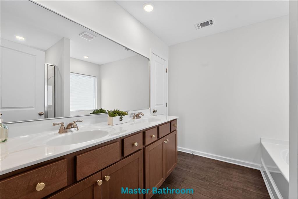 233 Bloomfield Circle Canton, GA 30114 - Photo 14 of 22 a bathroom with a double vanity sink and mirror