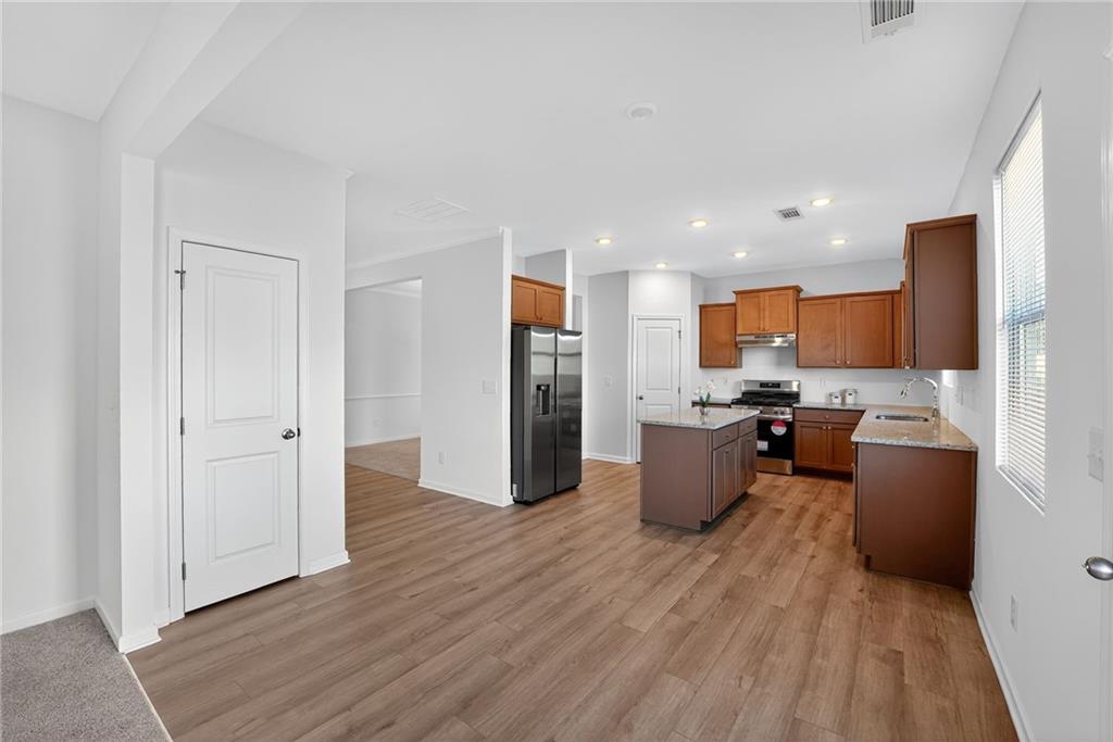 233 Bloomfield Circle Canton, GA 30114 - Photo 2 of 22 a kitchen with stainless steel appliances kitchen island wooden floors and wooden cabinets
