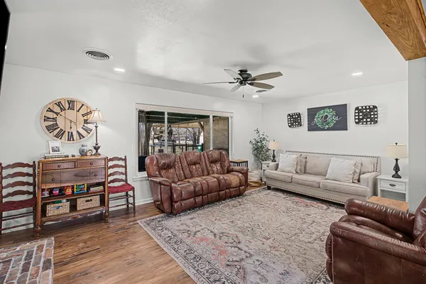 a living room with furniture a ceiling fan and a rug