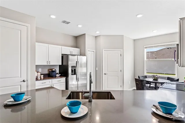 a kitchen with granite countertop a refrigerator and wooden floor