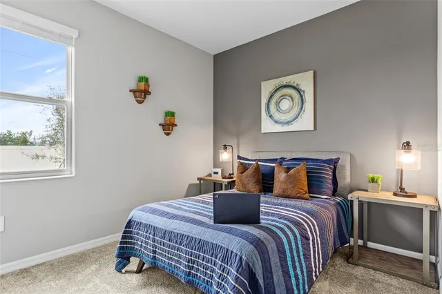 a bedroom with a bed and painting on the wall