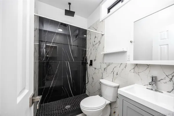 a bathroom with a sink toilet and shower