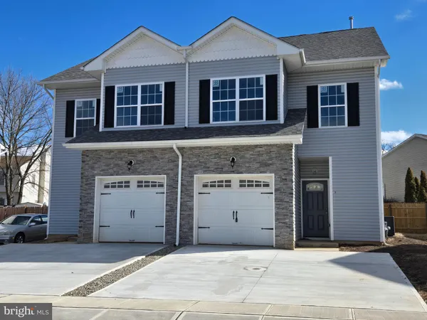 a front view of a house with a garage and a yard
