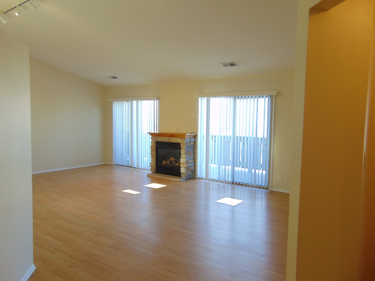 1662 Commodore Court, Unit 2 Schaumburg, IL 60193 - Photo 6 of 26 an empty room with wooden floor fireplace and windows