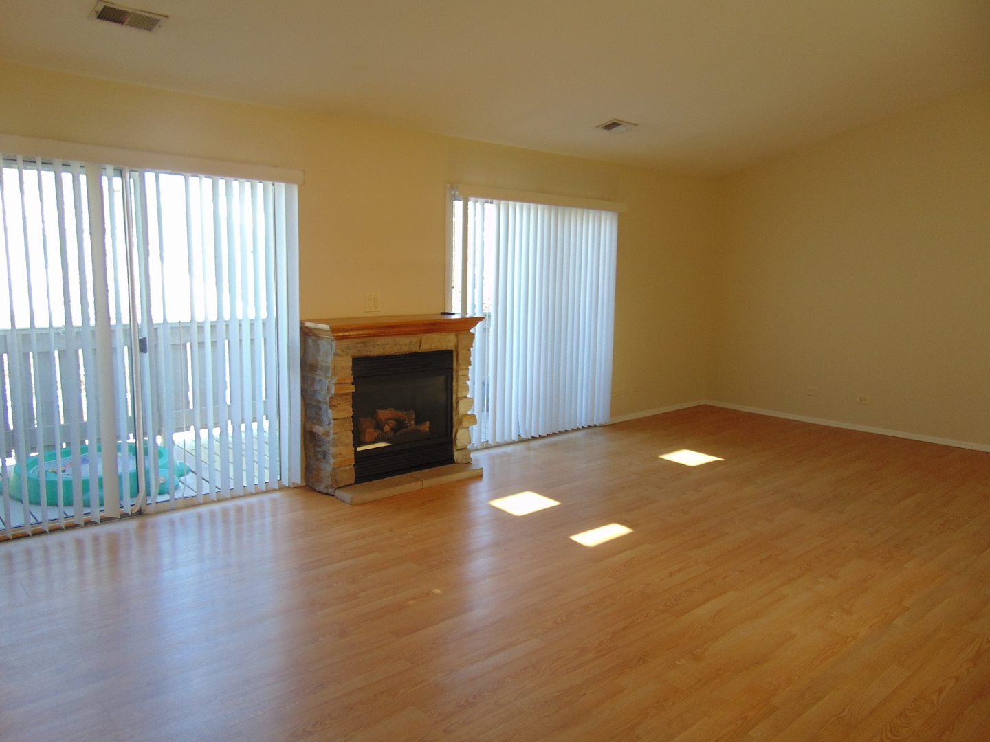 1662 Commodore Court, Unit 2 Schaumburg, IL 60193 - Photo 7 of 26 an empty room with wooden floor fireplace and windows
