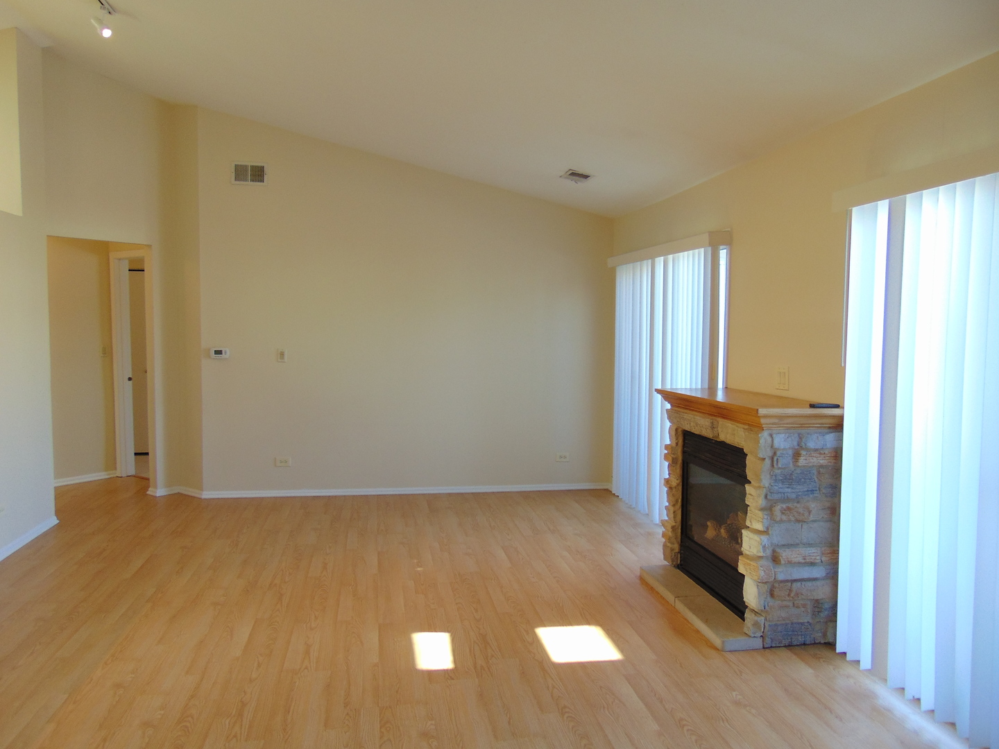 1662 Commodore Court, Unit 2 Schaumburg, IL 60193 - Photo 8 of 26 a view of empty room with wooden floor and fireplace