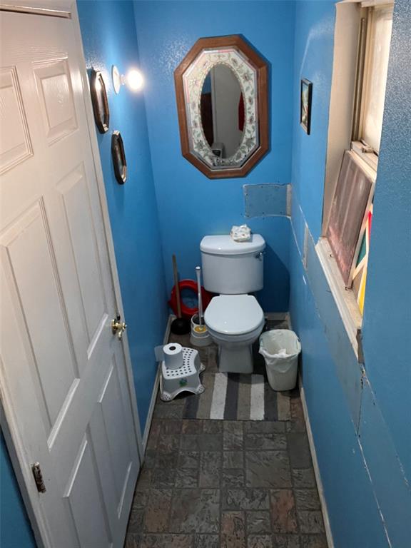 4838 Wisteria Street Dallas, TX 75211 - Photo 14 of 19 a bathroom with a toilet and a mirror