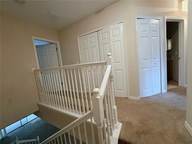 a view of a hallway with wooden floor and windows