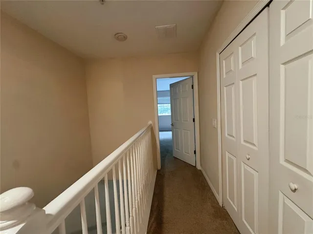 a view of a hallway with wooden floor and stairs