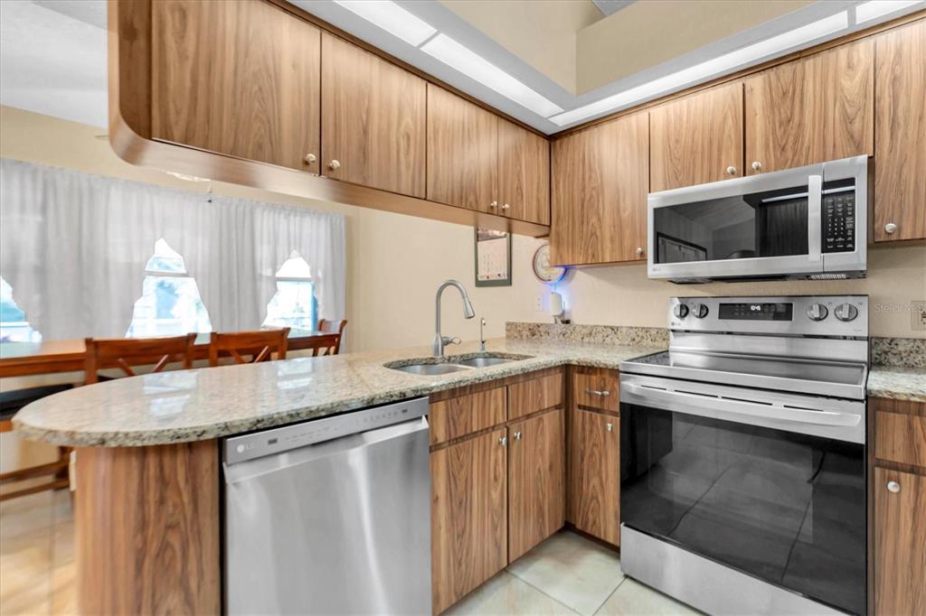 18809 Parade Road Hudson, FL 34667 - Photo 12 of 37 a kitchen with stainless steel appliances granite countertop a stove microwave and cabinets