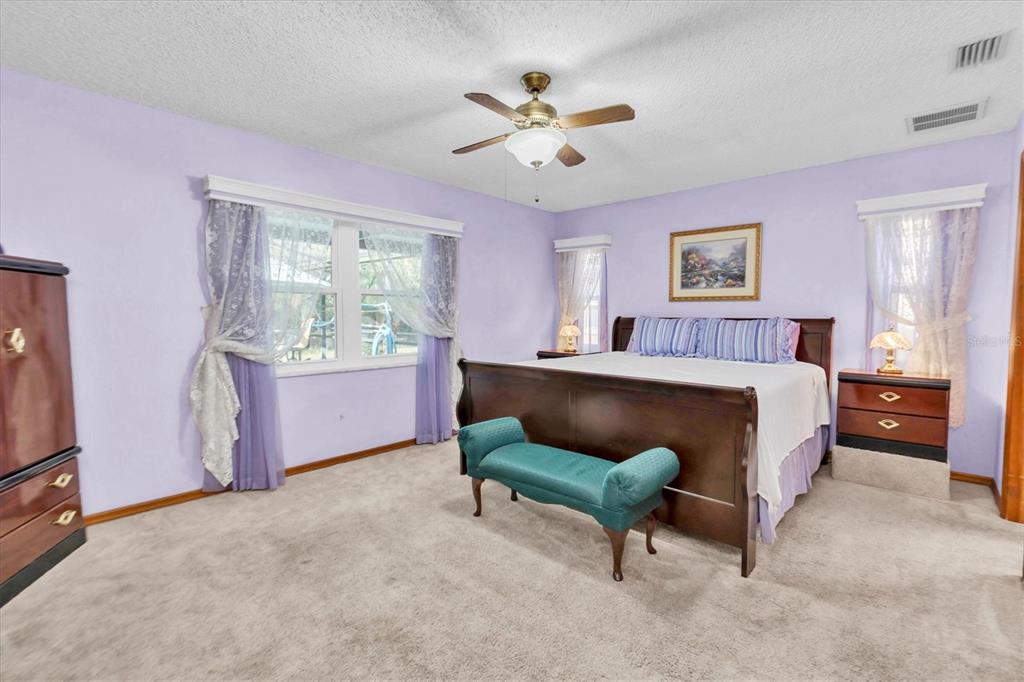 18809 Parade Road Hudson, FL 34667 - Photo 16 of 37 a bed room with a bed and a chandelier