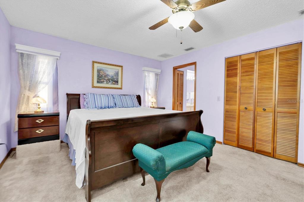 18809 Parade Road Hudson, FL 34667 - Photo 17 of 37 a bedroom with a bed and a chandelier
