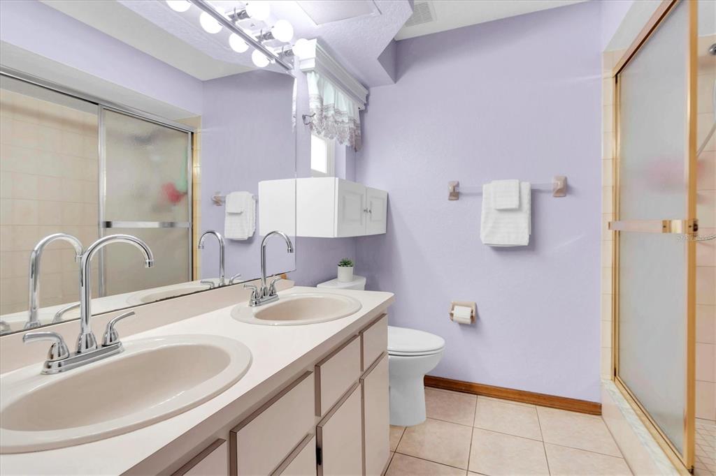 18809 Parade Road Hudson, FL 34667 - Photo 19 of 37 a bathroom with a sink a toilet a mirror and vanity