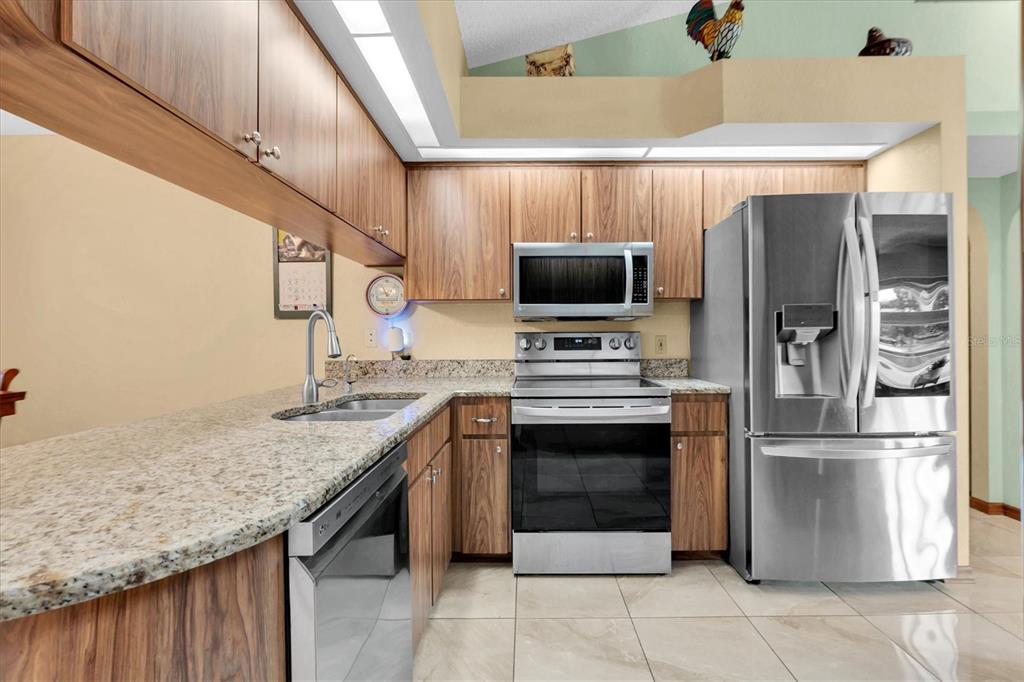 18809 Parade Road Hudson, FL 34667 - Photo 3 of 37 a kitchen with stainless steel appliances granite countertop a refrigerator a stove and a sink