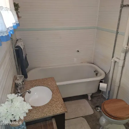 a bathroom with a granite countertop sink mirror vanity and toilet