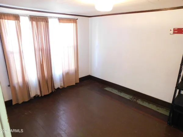 a view of a room with wooden floor and a window