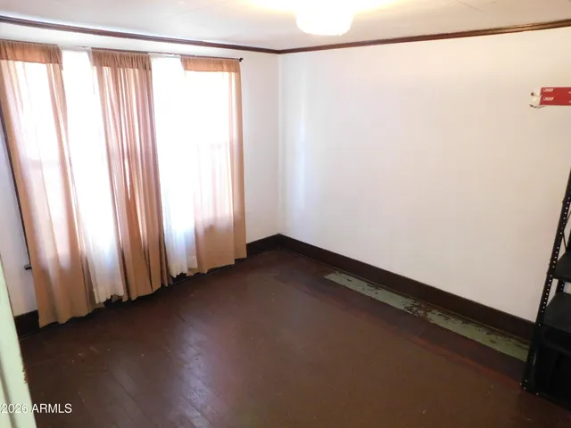 a view of a room with wooden floor and a window