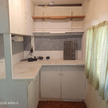 a view of kitchen cabinets and window