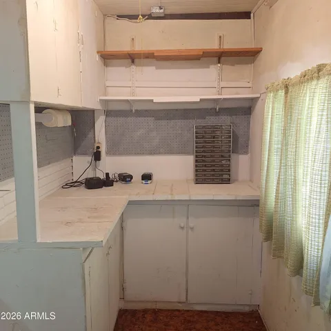 a view of kitchen cabinets and window
