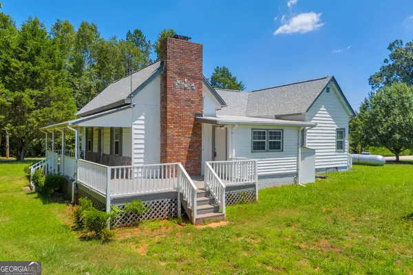 a view of a house with a yard and furniture