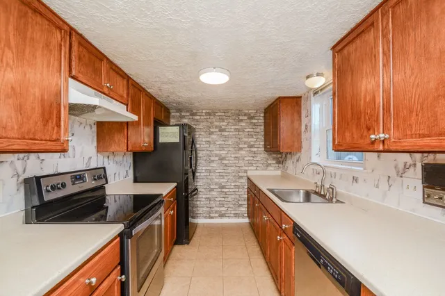 a kitchen with stainless steel appliances a sink stove and cabinets