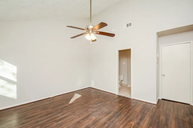 a view of a room with wooden floor and a ceiling fan