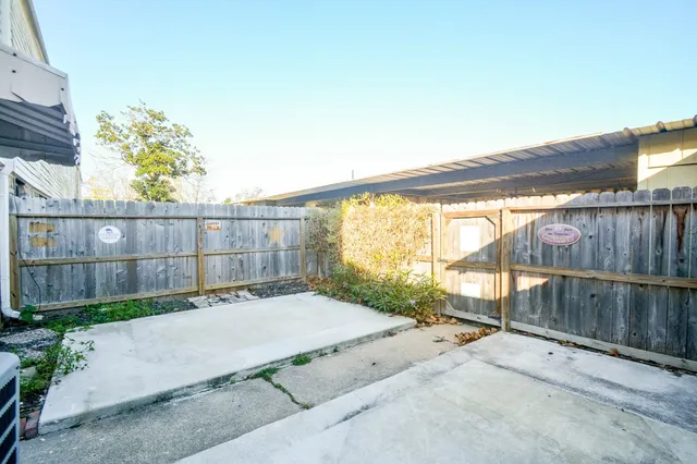 a view of backyard with wooden fence