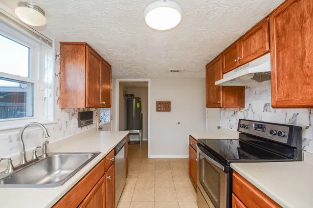 a kitchen with a sink a stove and cabinets