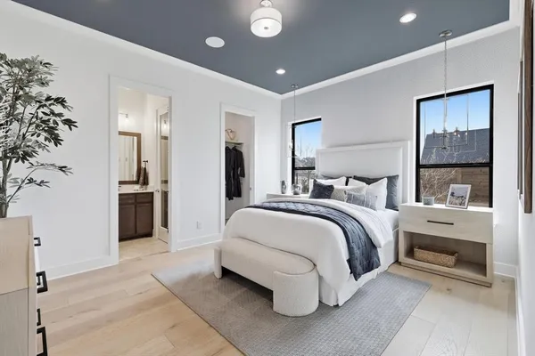 a spacious bedroom with a bed and a chandelier