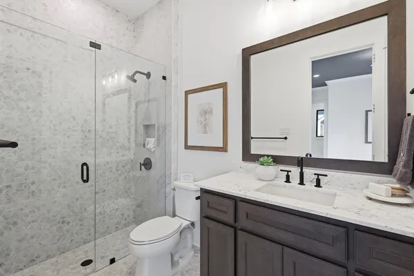a bathroom with a sink a toilet and shower