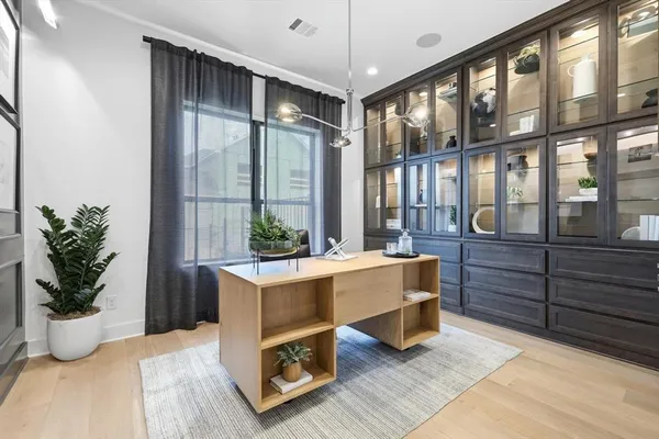 a room with lots of wooden furniture and potted plant