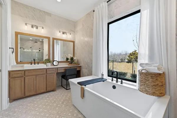 a large bathroom with a tub sink and mirror