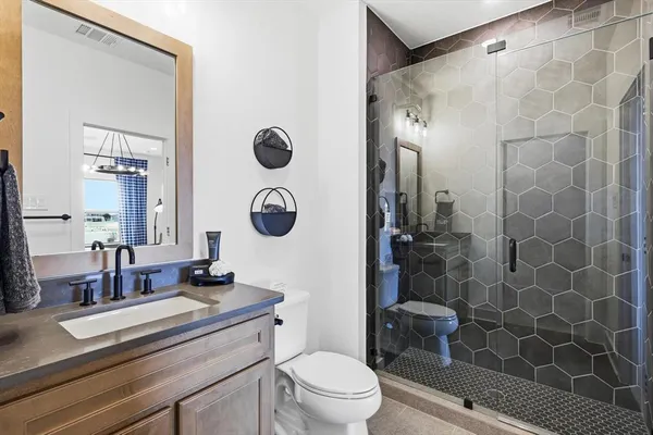 a bathroom with a sink a toilet a mirror and shower