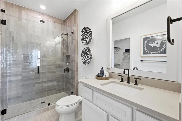 a bathroom with a sink a toilet and shower