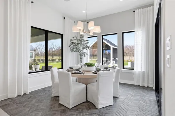 a dining room with furniture a chandelier and wooden floor