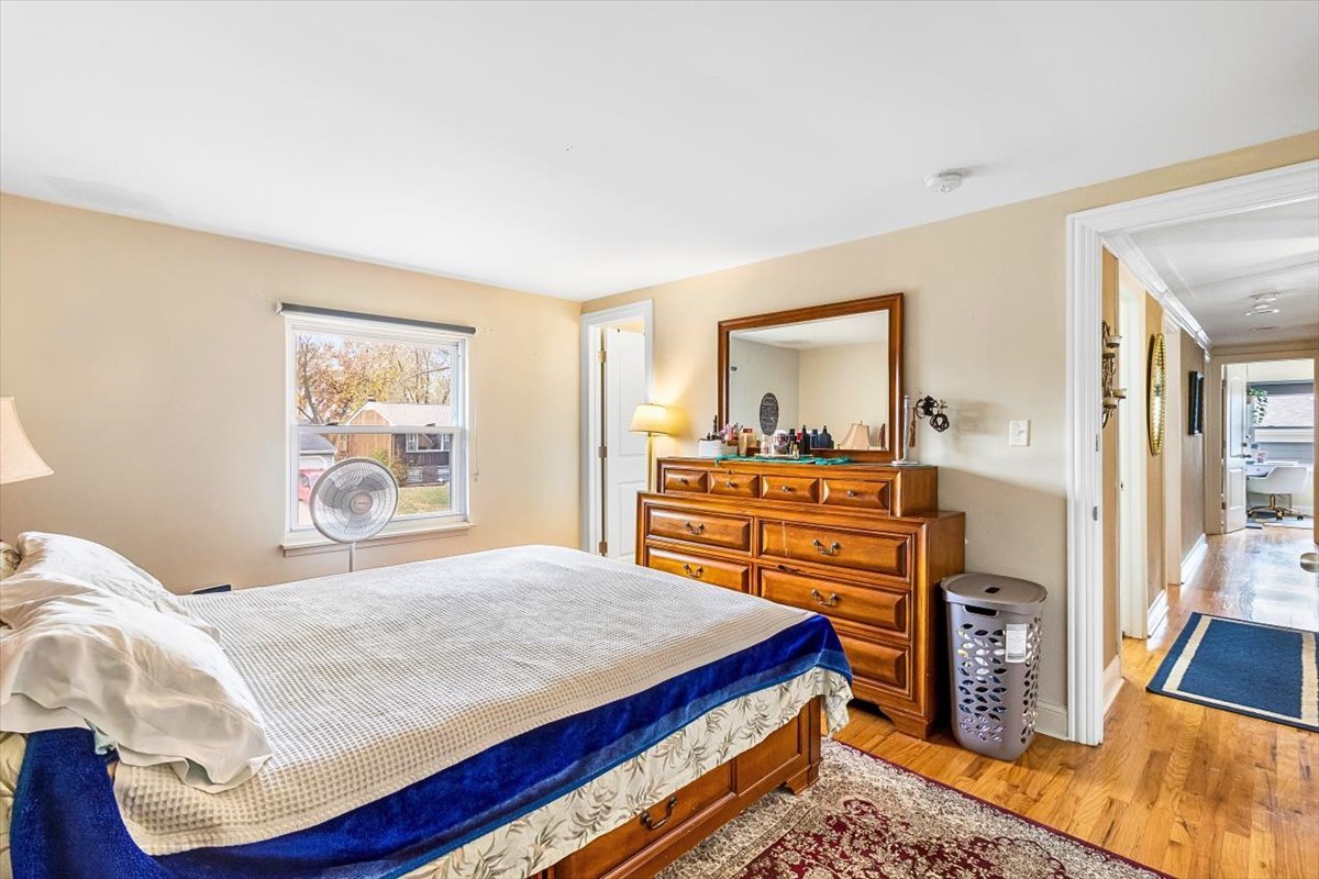6881 Hickory Street Hanover Park, IL 60133 - Photo 3 of 23 a bedroom with a bed and a dresser next to a window