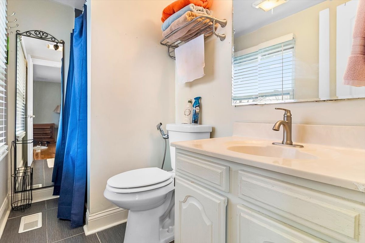 6881 Hickory Street Hanover Park, IL 60133 - Photo 5 of 23 a bathroom with a sink a toilet and a mirror