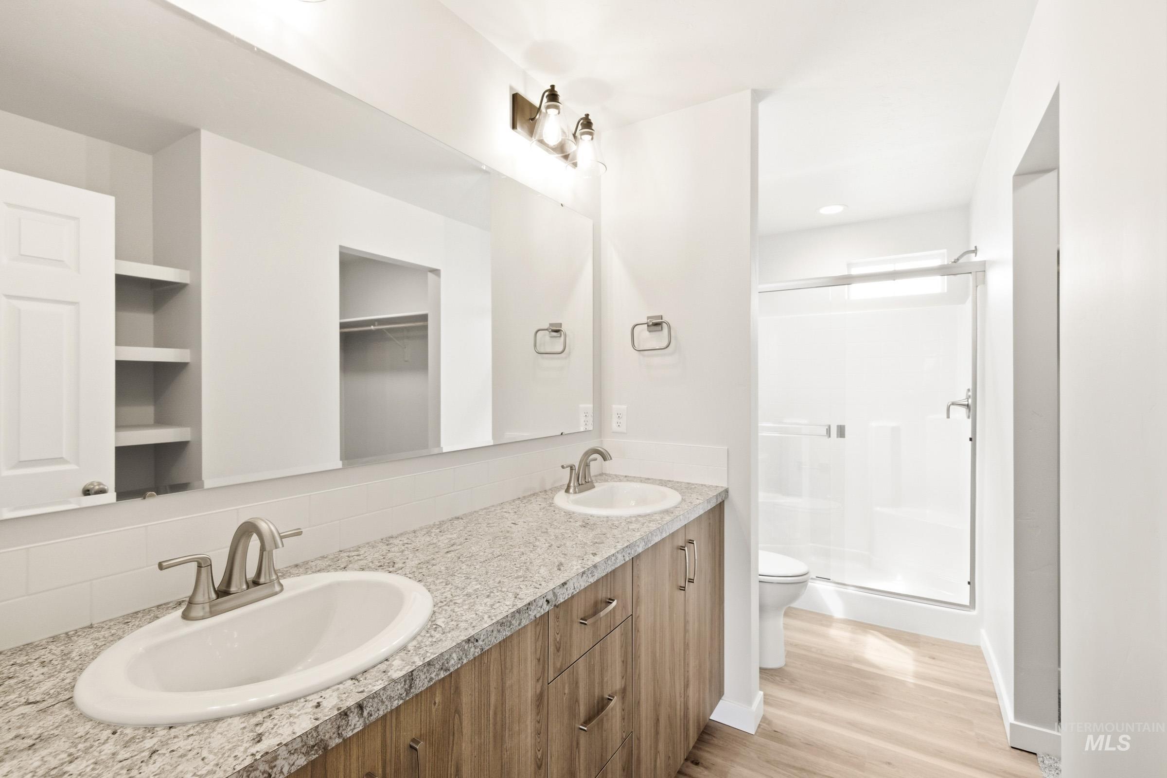 2446 West Fallon Loop Nampa, ID 83651 - Photo 16 of 19 Full bath with a shower stall, double vanity, light wood-style flooring, and recessed lighting