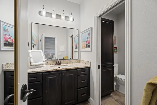 a bathroom with a granite countertop sink and a mirror