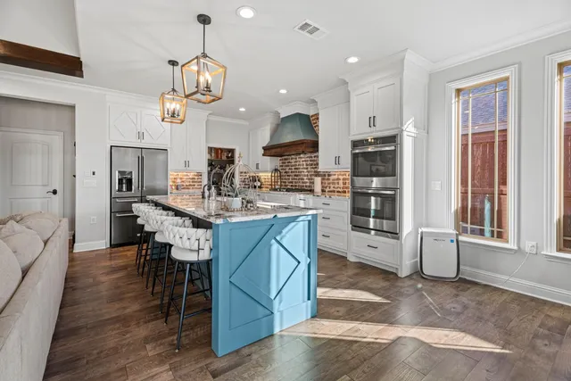 a kitchen with stainless steel appliances granite countertop a stove oven a sink dishwasher and a dining table with kitchen view