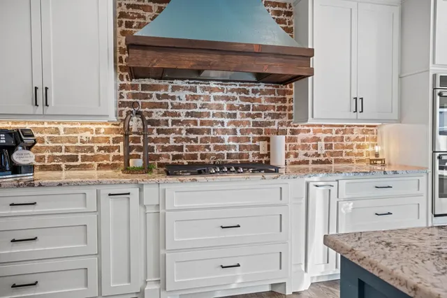 a kitchen with granite countertop white cabinets and appliances