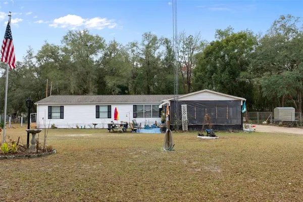 a view of a house with backyard and sitting area